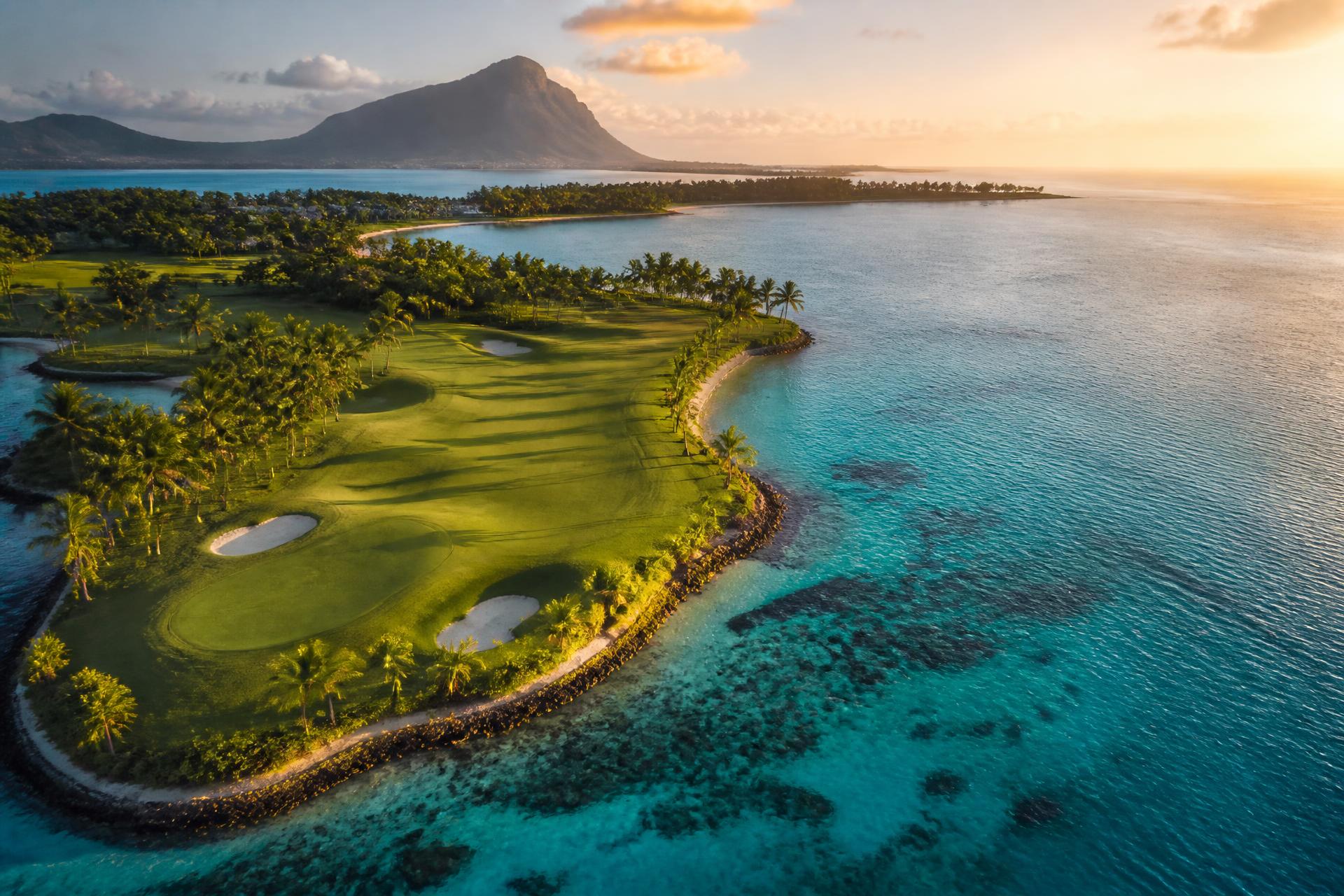 Aerial view of a tropical island golf course beside a turquoise lagoon in Mauritius